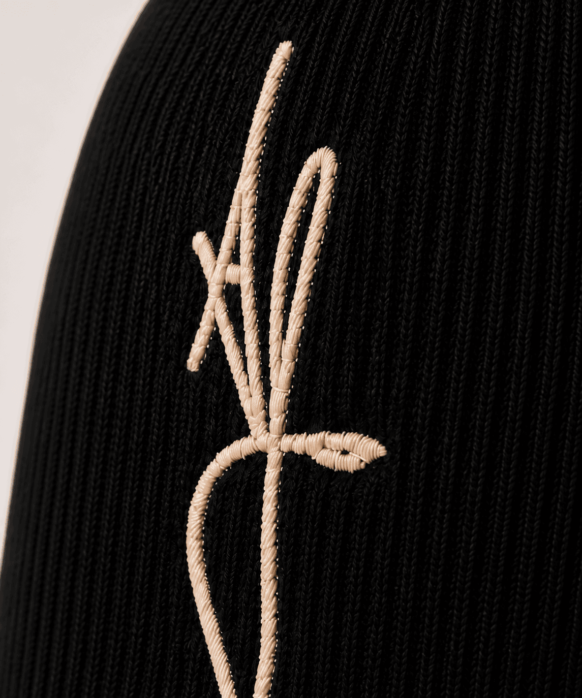 Nūr Signature Beanie in Noir, warm-bone signature AF and rib detail