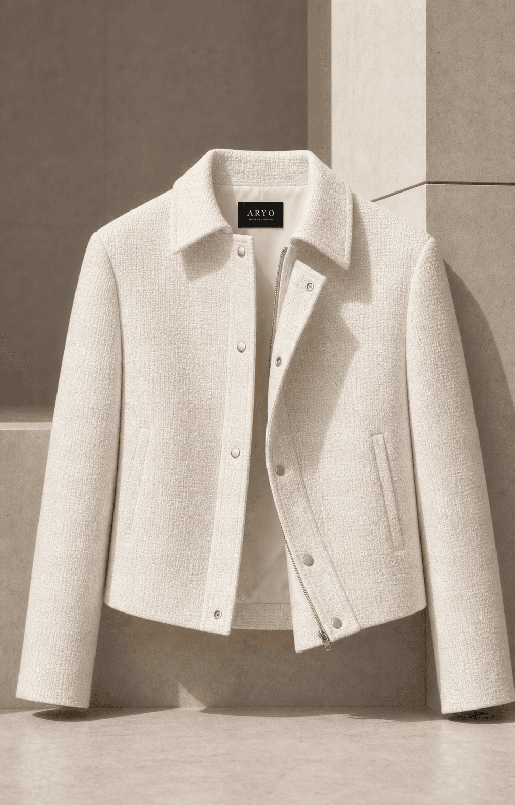 Open view of the Ivory Pennicella Jacket showing the lining, concealed placket, and ARYO neck label
