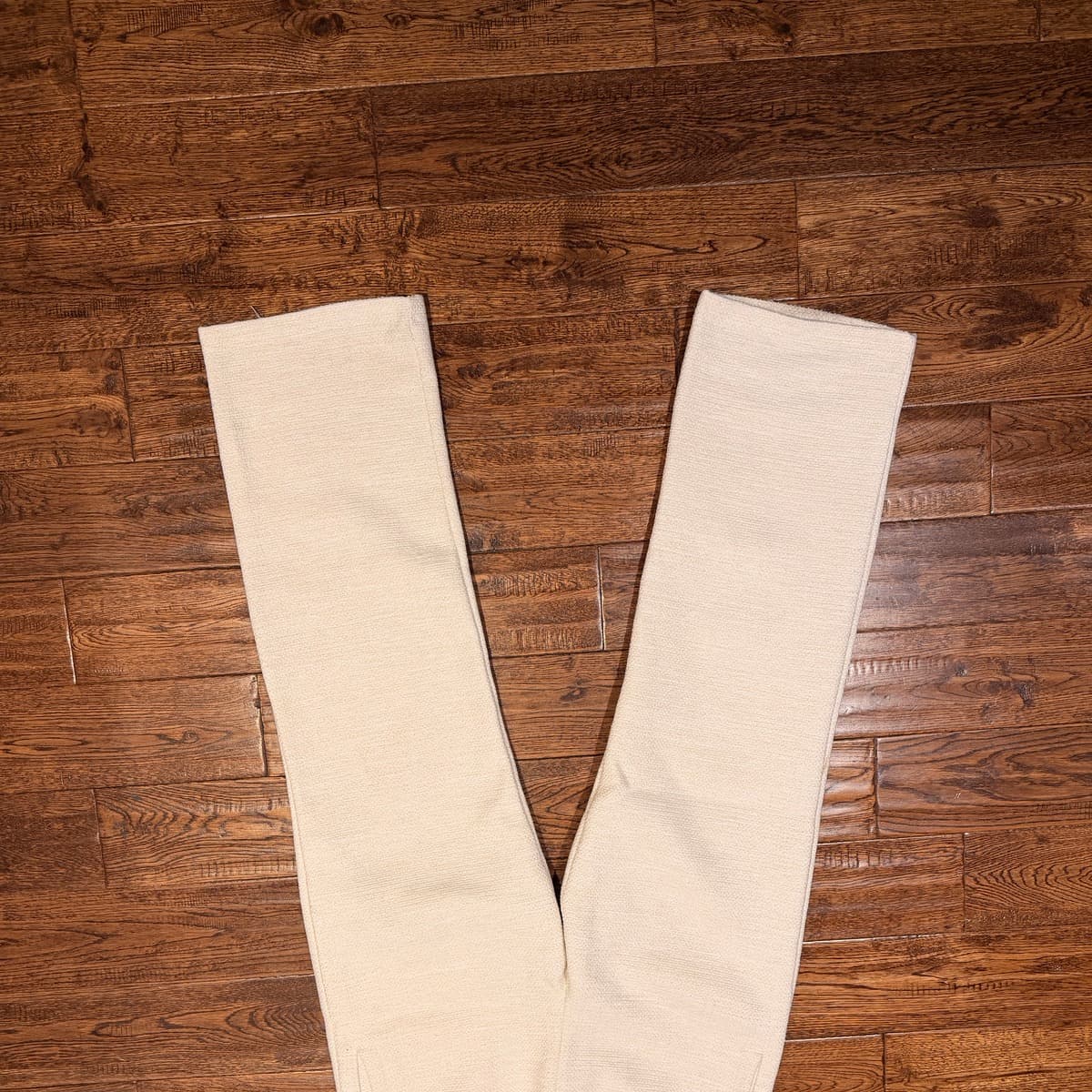Back pocket detail of the blue ARYO signature embroidery on the Ivory Essential Trouser